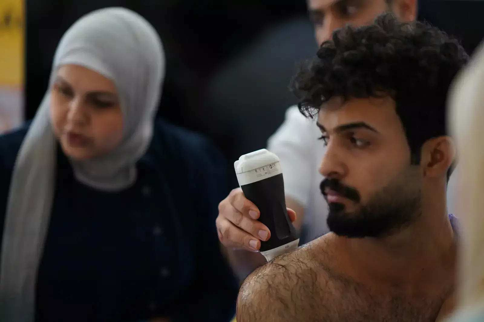 متدرب يفحص بجهاز Clarius بإشراف مدرّبة / A trainee scanning with Clarius under a trainer's guidance